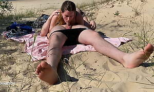 Nudist couple enjoying blowjob at the beach